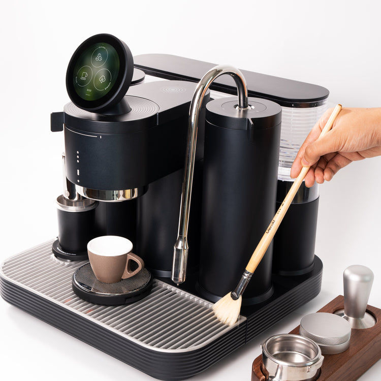 Cleaning a black espresso machine with built in grinder using Meraki home barista accessories.