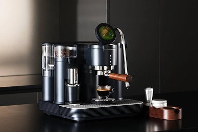 Meraki espresso machine on a dark countertop with a cup of espresso, tamper, and accessories