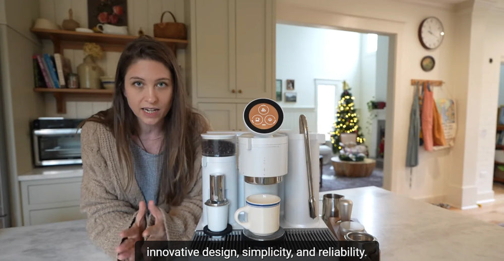 Christine from Christine’s Notebook presenting a white Meraki espresso machine in her kitchen.
