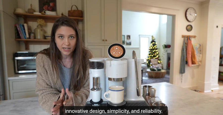 Christine from Christine’s Notebook presenting a white Meraki espresso machine in her kitchen.