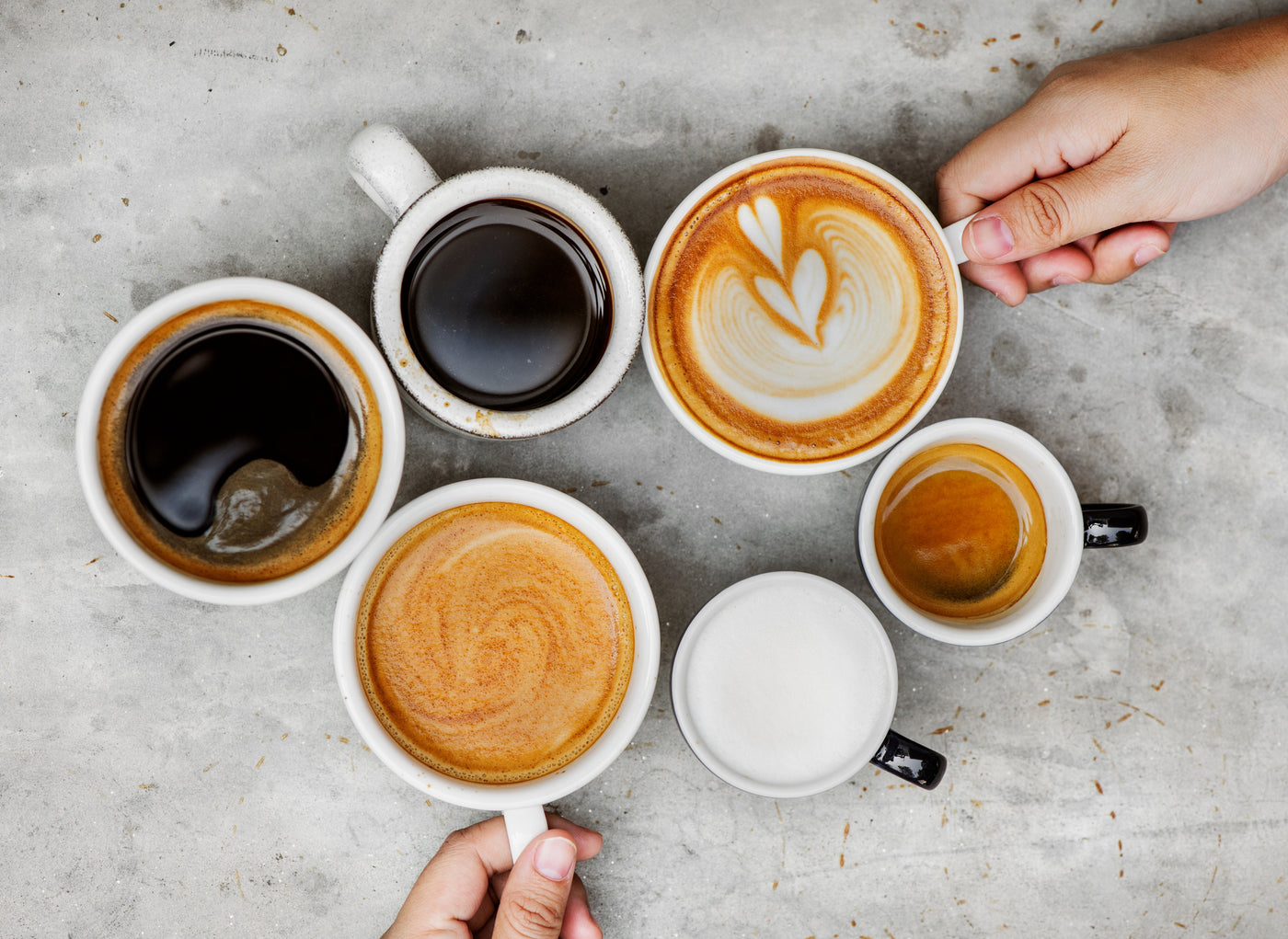 A top-down view of a specialty coffee menu including Latte, Americano, Cappuccino, and Flat White, illustrating the variety of espresso-based drinks.