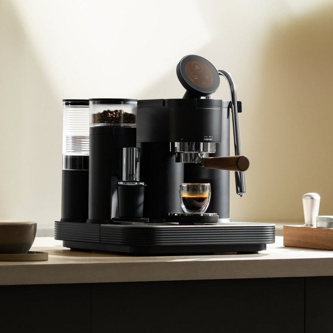 Black Meraki espresso machine with a commercial rotary pump on a home kitchen counter