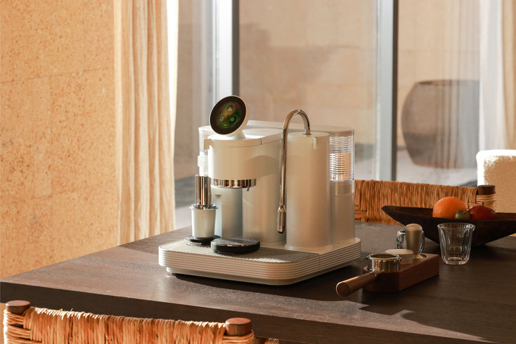 White Meraki espresso machine with integrated grinder and steam wand on a wooden table