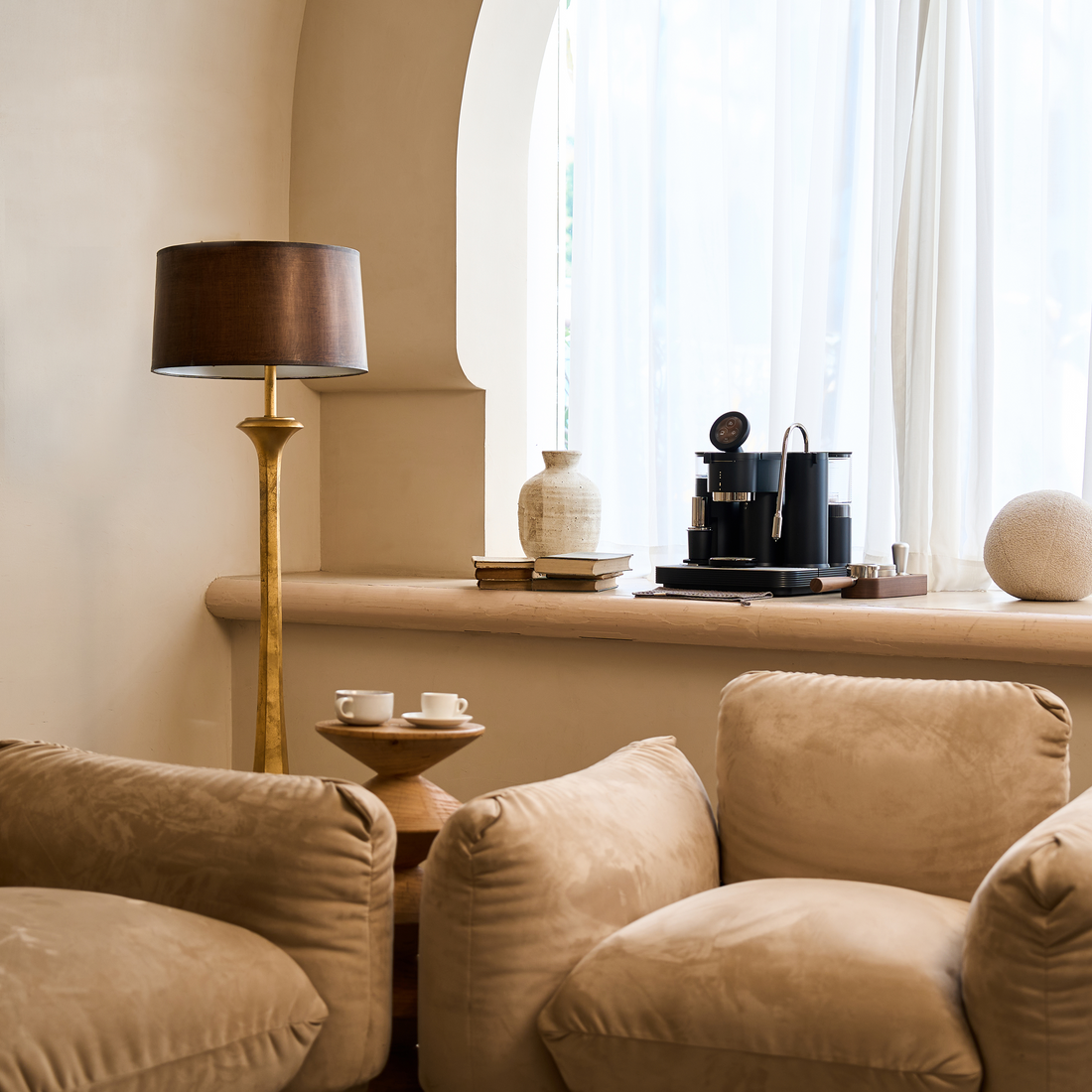 Black Meraki espresso machine with built-in grinder in a warm home interior