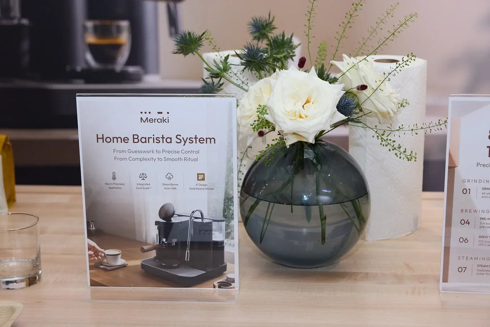 Meraki Home Barista System information card beside white flowers on the event counter.