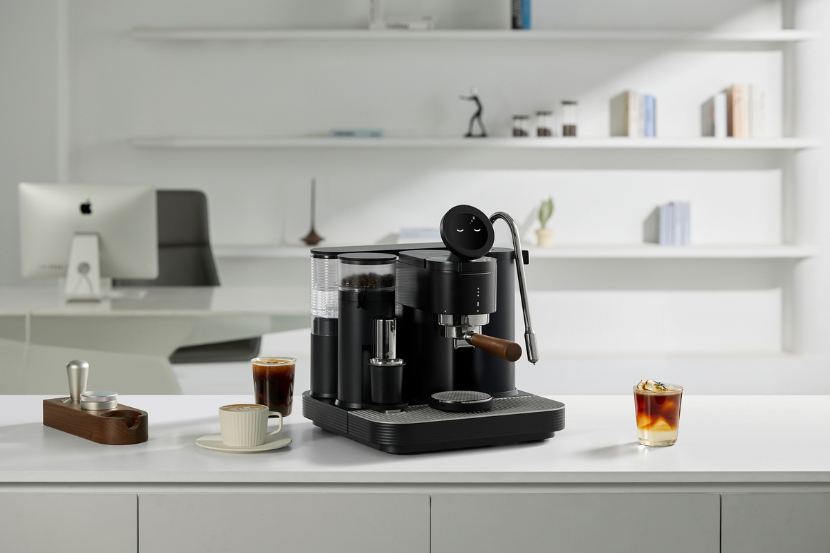 Black Meraki espresso machine with cups on a white counter
