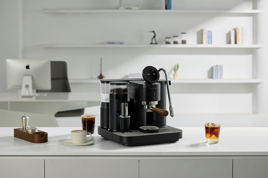Black Meraki espresso machine with cups on a white counter