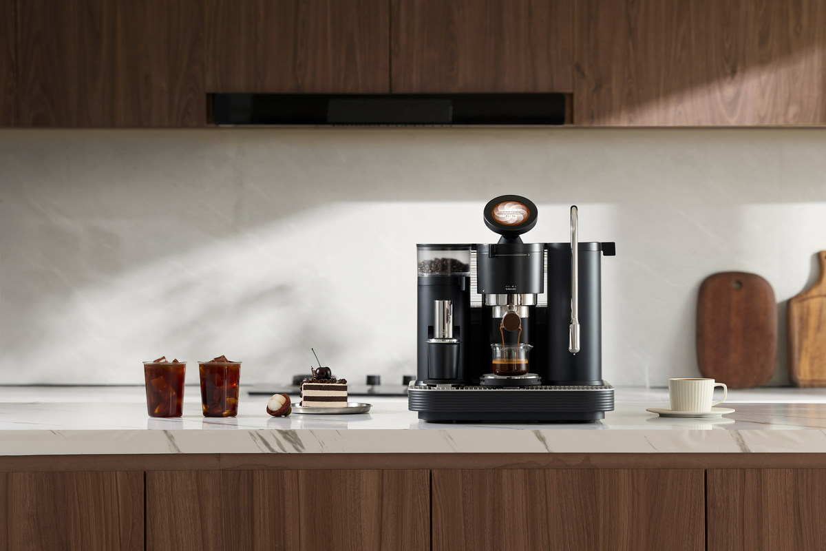 Black Meraki espresso machine with coffee drinks on a kitchen counter