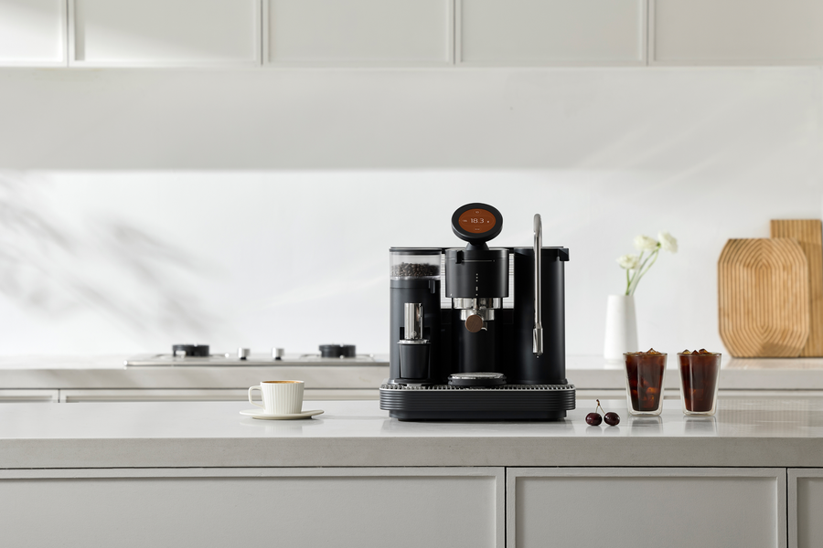Black Meraki espresso machine with two iced coffee drinks on a counter