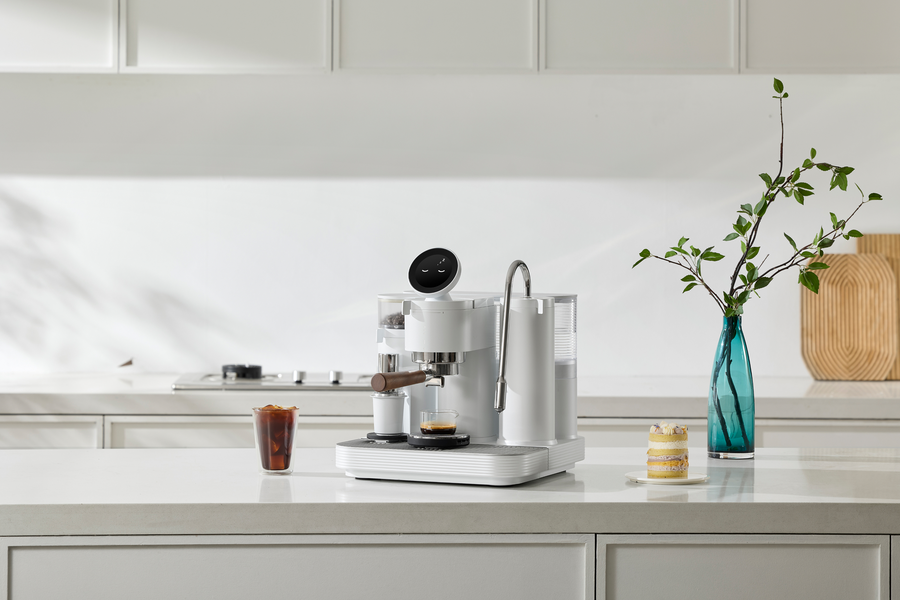 White Meraki espresso machine on a spacious white kitchen counter