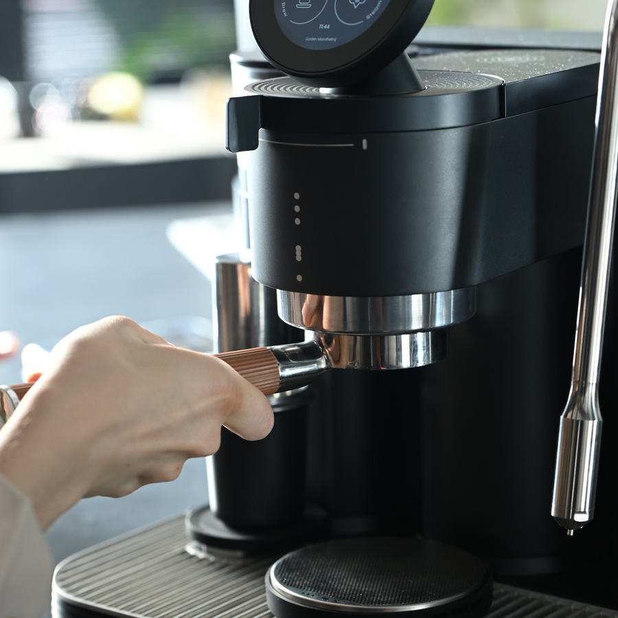 Grinding coffee with a black Meraki espresso machine