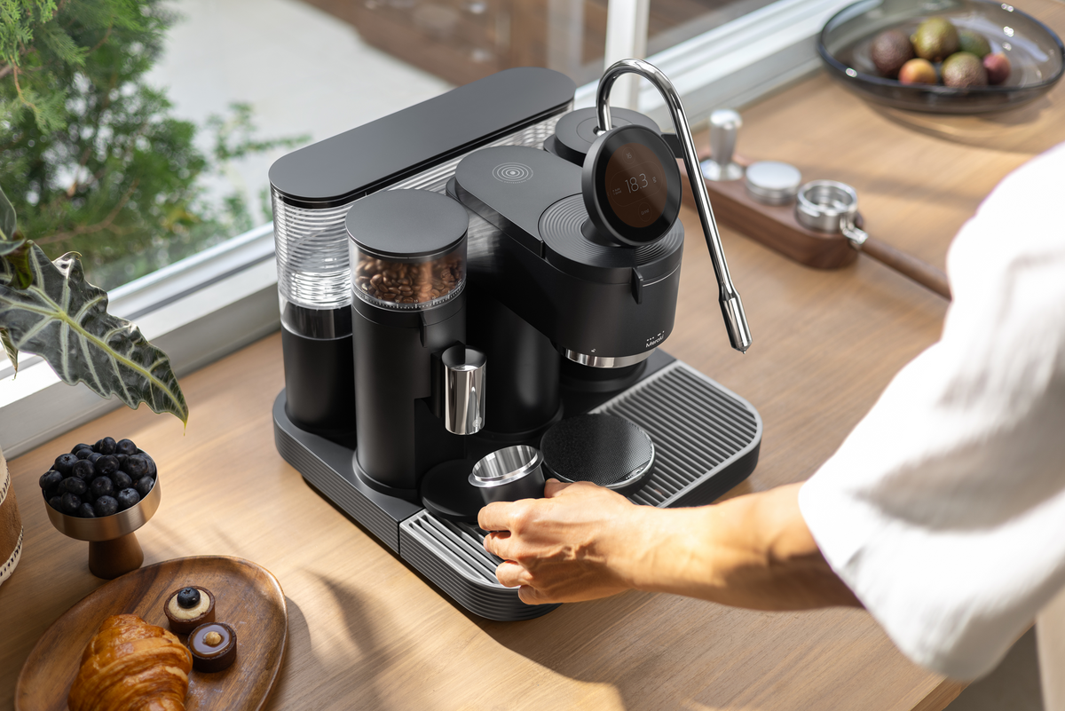 Overhead view of a person using a black Meraki espresso machine