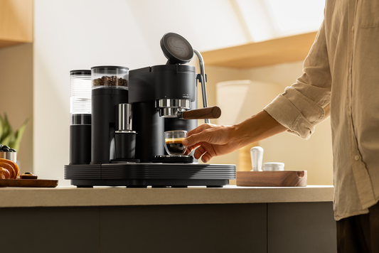 Taking a coffee cup from a black Meraki espresso machine