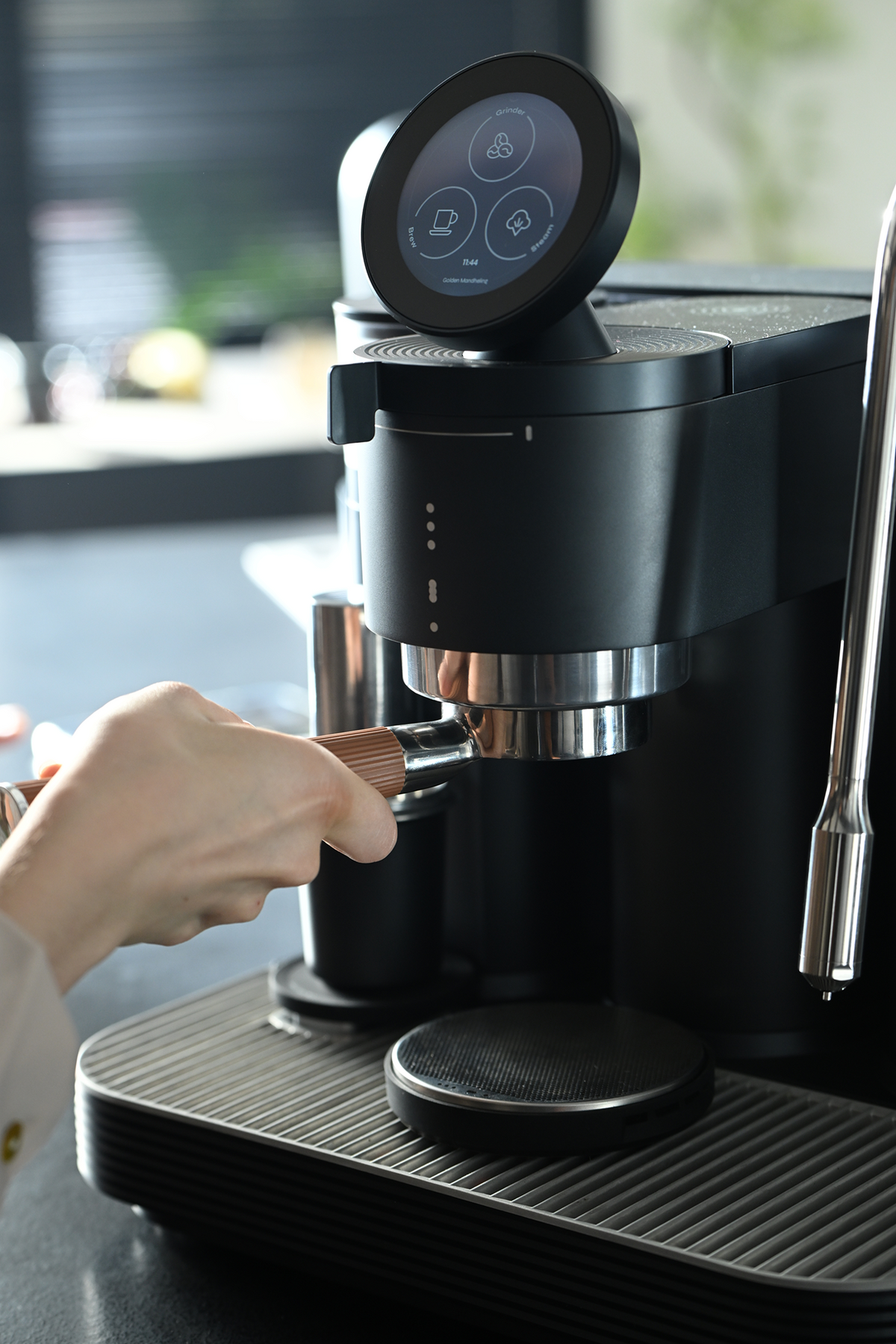 Using the grinder on a black Meraki espresso machine