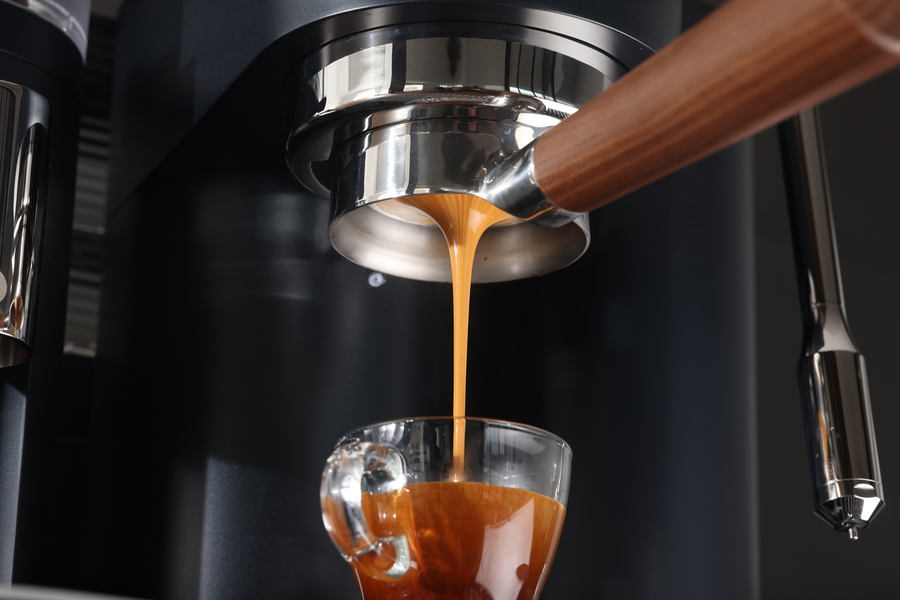 Espresso flowing from a bottomless portafilter into a clear glass