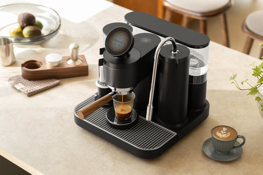 Black Meraki espresso machine with coffee cups and a glass of coffee