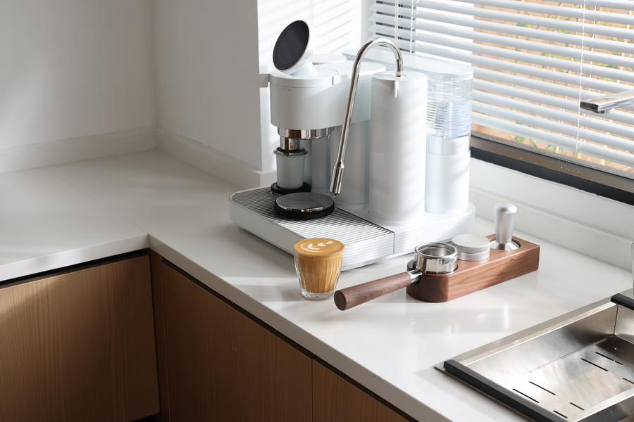 White Meraki espresso machine with a latte and wooden accessory station