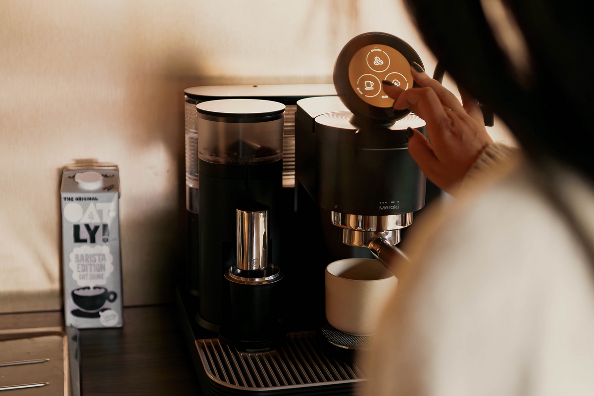 Adjusting the round touchscreen on a black Meraki espresso machine