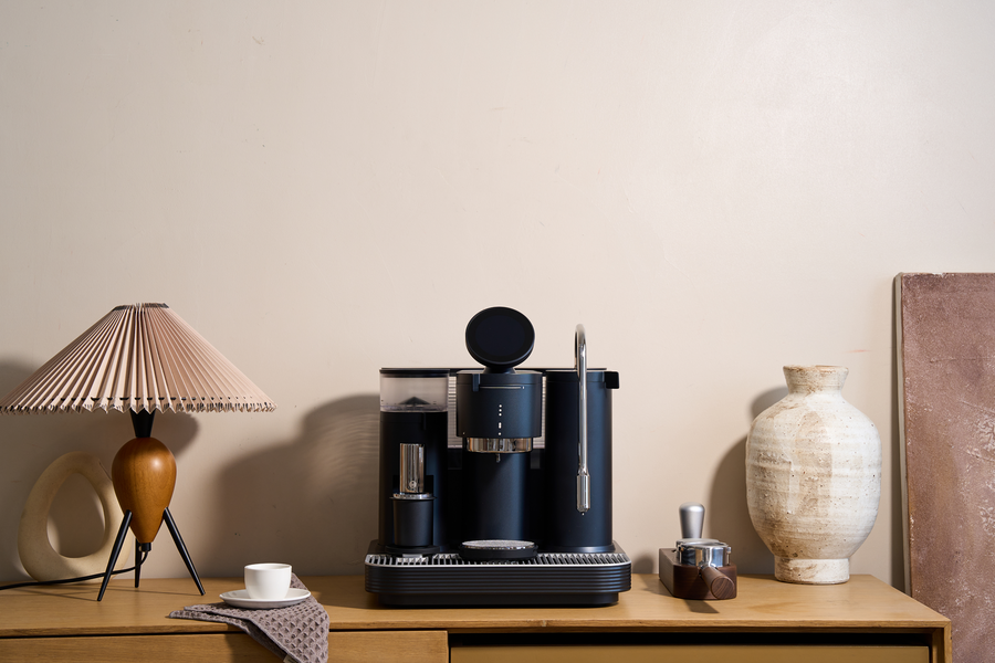 Black Meraki espresso machine arranged on a console in a living space