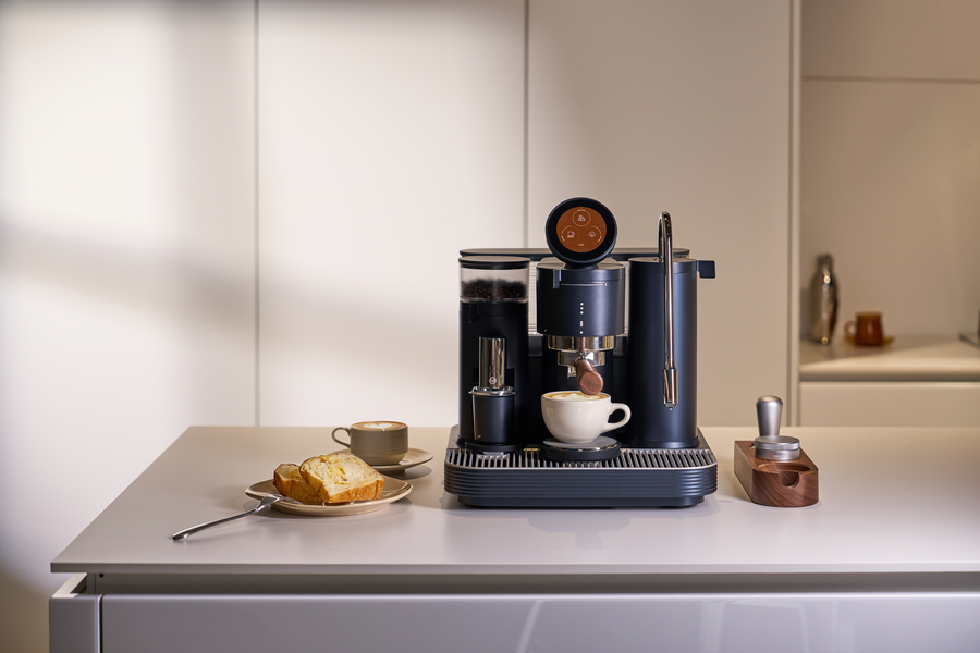 Black Meraki espresso machine with coffee accessories on a bright counter