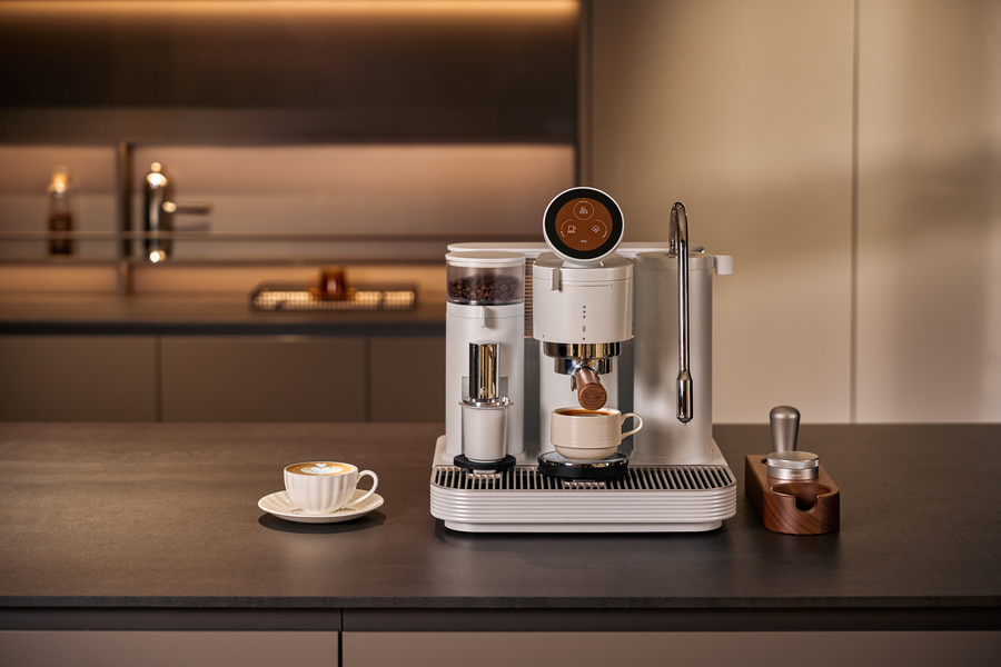 White Meraki espresso machine in a warmly lit kitchen