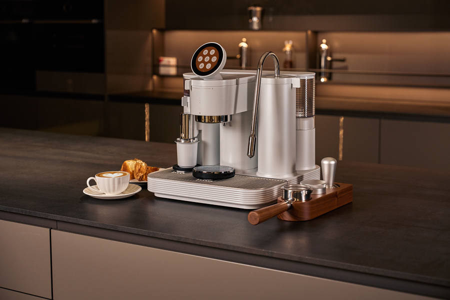 White Meraki espresso machine on a dark kitchen counter