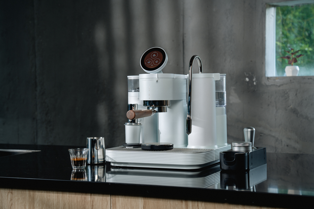 White Meraki espresso machine shown at an angle in natural light