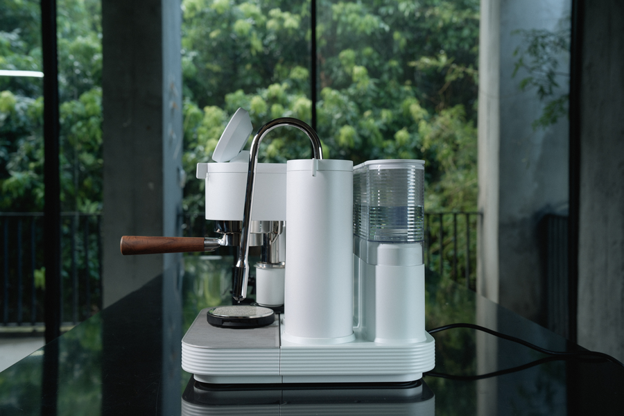 Side view of a white Meraki espresso machine and its water tank