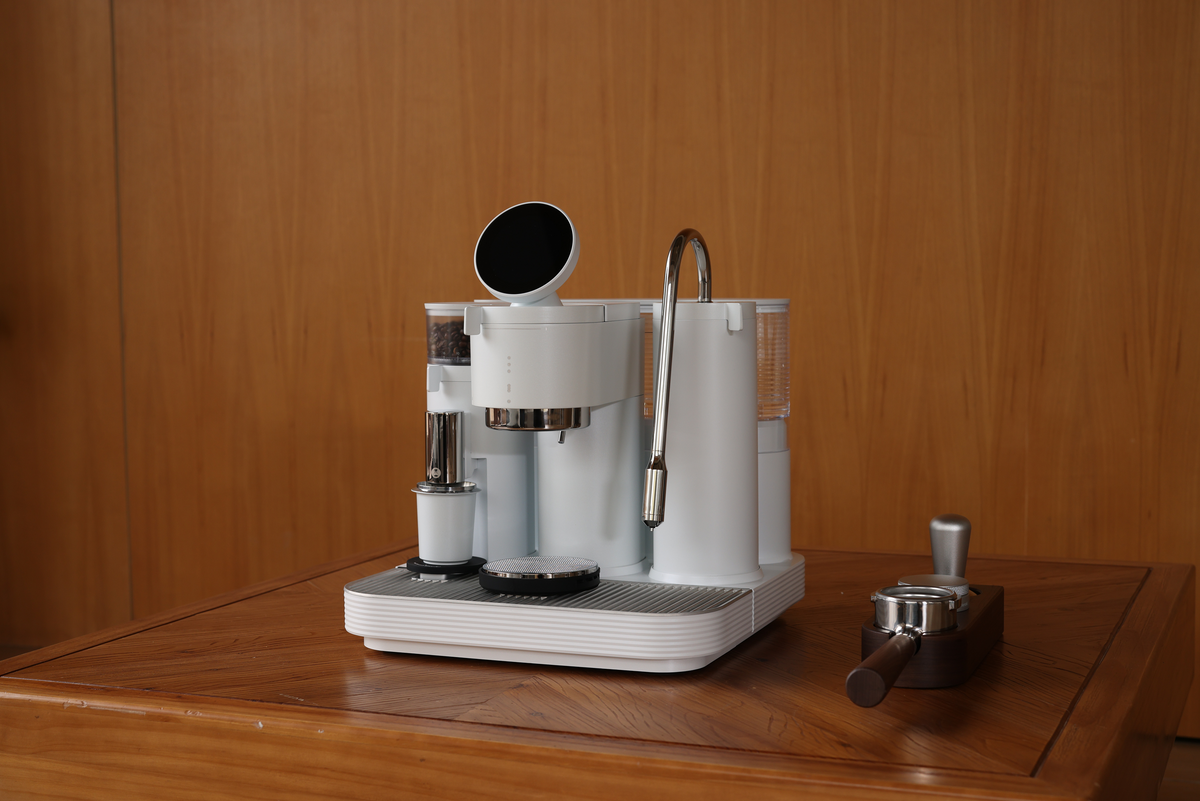 White Meraki espresso machine on a wooden table
