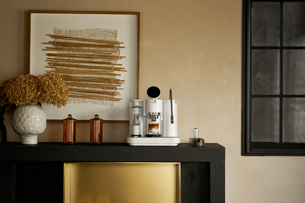 White Meraki espresso machine in a green kitchen with wall art