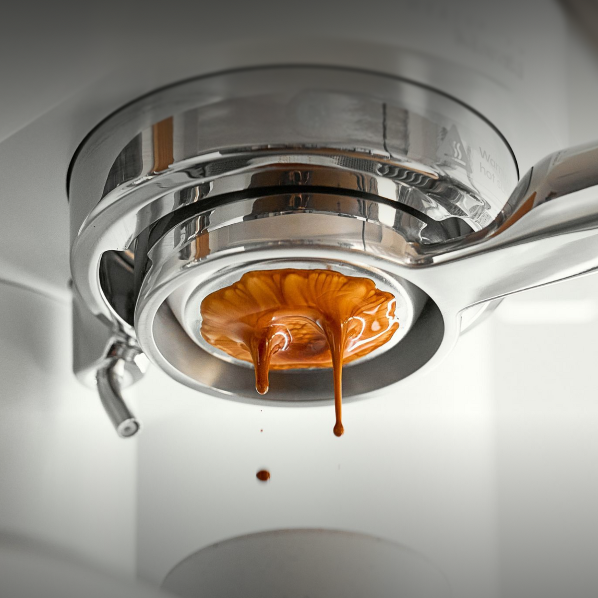 Espresso flowing unevenly through a bottomless portafilter during extraction