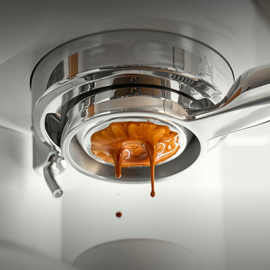 Espresso flowing unevenly through a bottomless portafilter during extraction