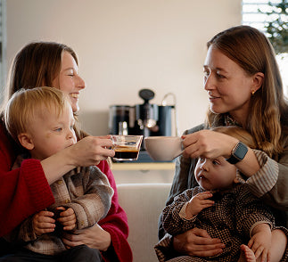 A dual boiler espresso machine being used in a family setting to craft multiple lattes quickly.