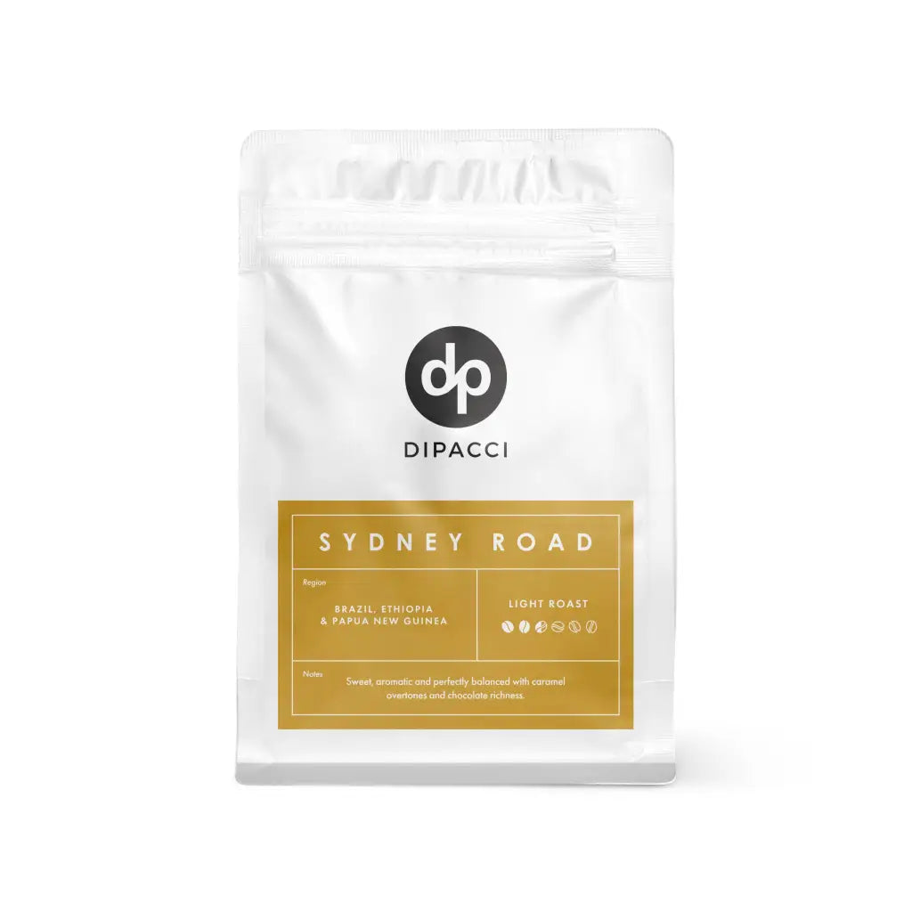 A bag of Dipacci Sydney Road light roast coffee beans featuring notes of caramel and chocolate.
